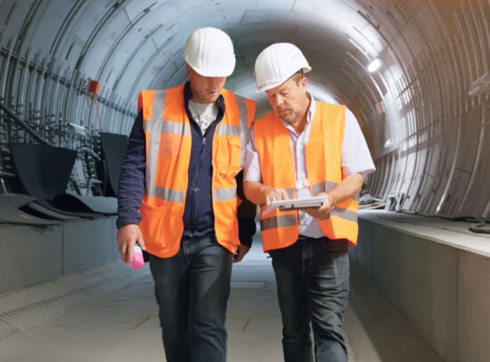 Two construction workers performing a vibration analysis in a railway tunnel. Two construction workers performing a vibration analysis in a railway tunnel.