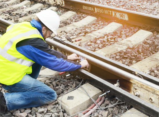 Worker installing measuring devices for vibration analysis on railway tracks. Worker installing measuring devices for vibration analysis on railway tracks.