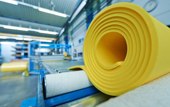 Roll of yellow polyurethane elastomer on a conveyor belt, vibration isolation.