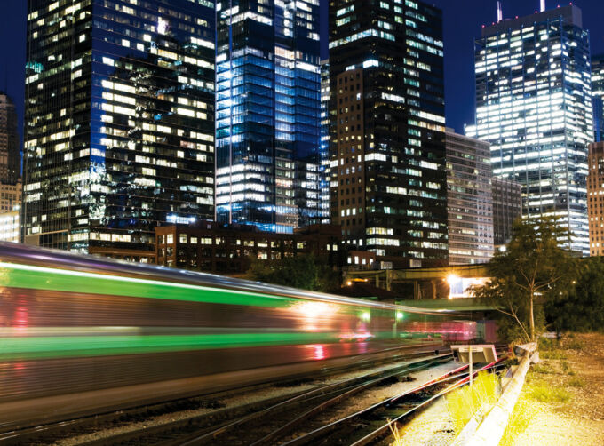 Commuter train at night in front of skyscrapers. Example of structure-borne noise insulation. Commuter train at night in front of skyscrapers. Example of structure-borne noise insulation.