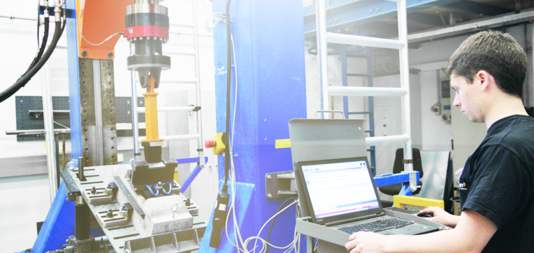 Engineer monitoring system testing/vibration analysis with a laptop in the Getzner laboratory. Engineer monitoring system testing/vibration analysis with a laptop in the Getzner laboratory.